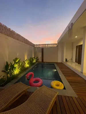 a swimming pool with two inflatable flamingos in a house at CASA NOOA Kerobokan in Kerobokan