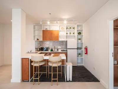 a kitchen with a counter and stools in a room at The Cruise Berawa - Design Apartments & Penthouses by CPM Bali in Canggu