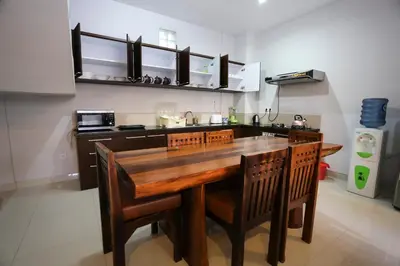 a kitchen with a wooden table and some chairs at Nyoman Villa Sanur in Sanur