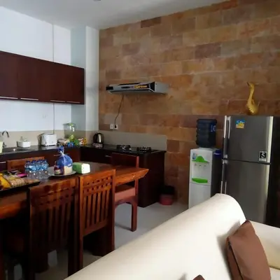 a kitchen with a stainless steel refrigerator and a table at Nyoman Villa Sanur in Sanur