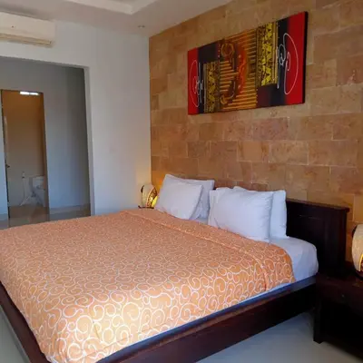 a bedroom with a bed with a brick wall at Nyoman Villa Sanur in Sanur