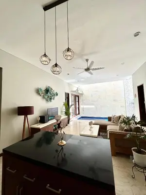 a living room with a ceiling fan and a couch at MJ Orchid Residence in Seminyak