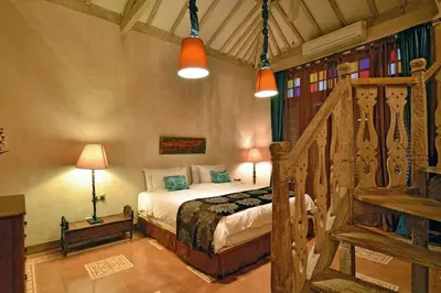 a bedroom with a bed and a staircase with lights at Moments Villa in Jimbaran