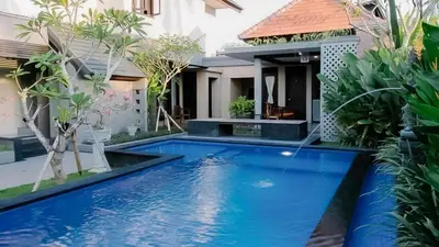 a swimming pool in front of a villa at arimanu rooms in Kuta