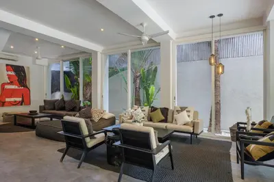 a living room with couches and chairs and a large window at Villa Levi by GORO in Seminyak