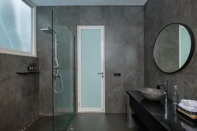 a bathroom with a glass shower and a sink at Villa Levi by GORO in Seminyak