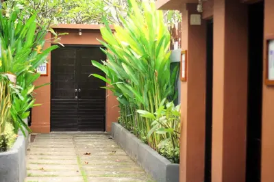 a driveway leading to a black garage with plants at Private villa with swimming pool in Kuta