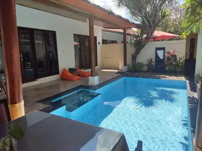 a swimming pool in front of a house at Private villa with swimming pool in Kuta
