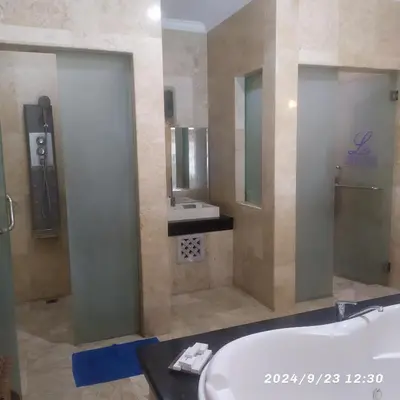 a bathroom with a tub and a sink and a mirror at Private villa with swimming pool in Kuta