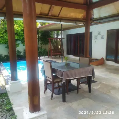 a patio with a table and chairs and a pool at Private villa with swimming pool in Kuta