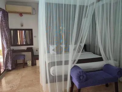 a bedroom with a bed and a chair and a desk at Private villa with swimming pool in Kuta