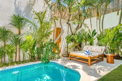 a pool with a couch and a chair next to aitating at Villa Aztec - 6BDR private pool and garden in Seminyak