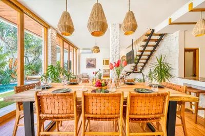 a dining room with a wooden table and chairs at Villa Aztec - 6BDR private pool and garden in Seminyak
