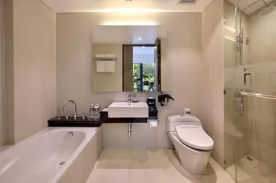 a bathroom with a toilet and a sink and a bath tub at Hotel NEO+ Kuta Legian by ASTON in Legian