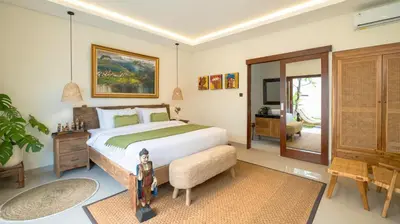 a bedroom with a bed and a chair and a table at Villa Lange 2 by Villa Finder in Seminyak
