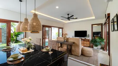 a living room with a dining table and a television at Villa Lange 2 by Villa Finder in Seminyak