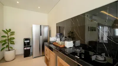 a kitchen with a black counter and a stainless steel refrigerator at Villa Lange 2 by Villa Finder in Seminyak