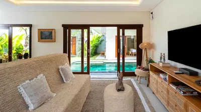 a living room with a couch and a tv at Villa Lange 2 by Villa Finder in Seminyak