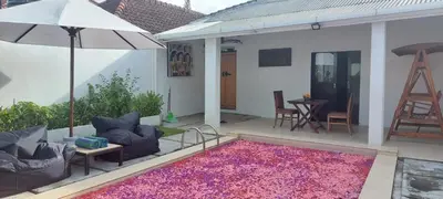 a patio with a purple rug and an umbrella at Village Pool Private In Kuta Bali in Legian