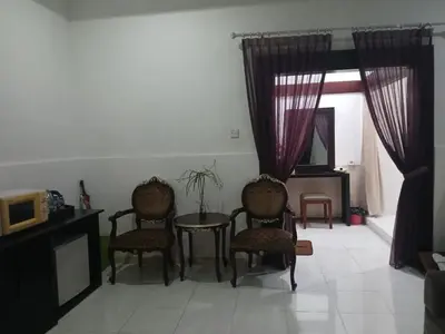 a living room with chairs and a table and a tv at Village Pool Private In Kuta Bali in Legian