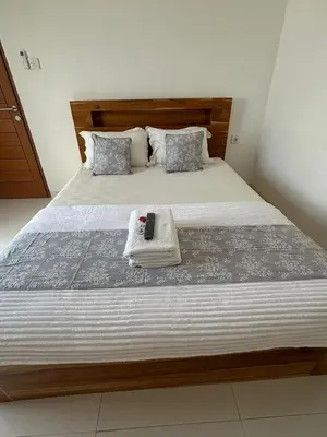 a bedroom with a large bed with a wooden headboard at Jabu Hasian Bali in Kerobokan
