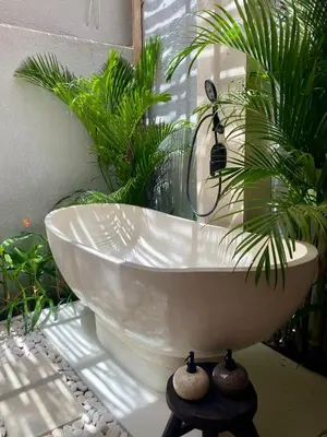 a white bath tub with plants in a bathroom at Paradise Haven in Nusa Dua in Nusa Dua