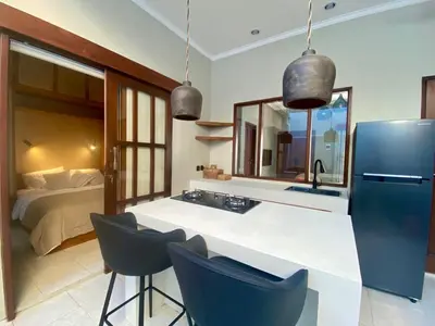 a kitchen with a sink and a refrigerator and a bed at Paradise Haven in Nusa Dua in Nusa Dua