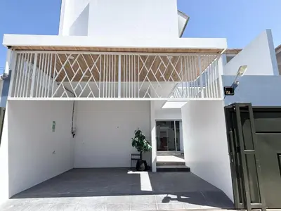 a white house with a wooden roof at Bellagio Villas in Seminyak