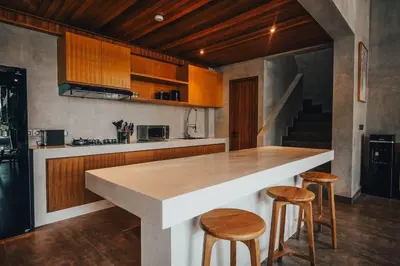 a kitchen with a large counter and two stools at Villa Cintamu - Modern Spacious Villa in Prime Berawa Location in Canggu