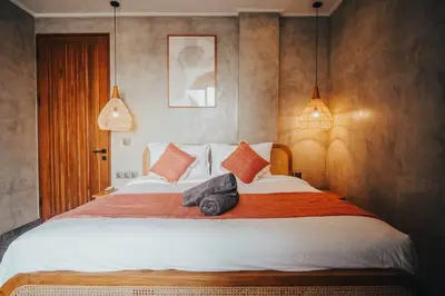 a bedroom with a large bed with orange and white pillows at Villa Cintamu - Modern Spacious Villa in Prime Berawa Location in Canggu