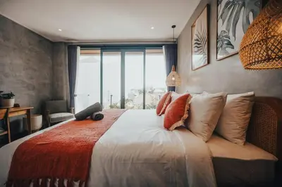 a bedroom with a large bed with a large window at Villa Cintamu - Modern Spacious Villa in Prime Berawa Location in Canggu