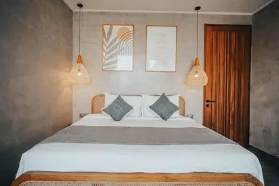 a bedroom with a large white bed with two pillows at Villa Cintamu - Modern Spacious Villa in Prime Berawa Location in Canggu