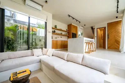 a living room with a white couch and a large window at Casanna Umalas in Canggu