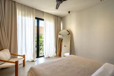 a bedroom with a mirror and a bed and a chair at Casanna Umalas in Canggu