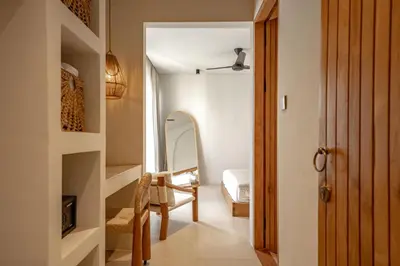 a hallway with a room with a bed and a chair at Casanna Umalas in Canggu