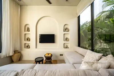 a living room with a white couch and a tv at Casanna Umalas in Canggu