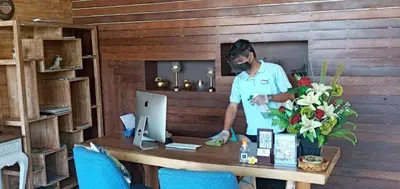 a man standing at a table with a computer at Amara Villa Umalas Bali in Canggu