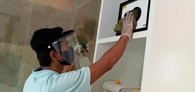 a man installing a mirror in a bathroom at Amara Villa Umalas Bali in Canggu