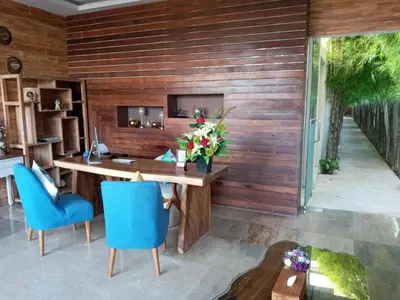 a wooden wall with a desk and blue chairs at Amara Villa Umalas Bali in Canggu