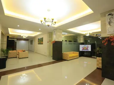 a lobby with couches and a television in a building at Bali Mega Hotel in Jimbaran