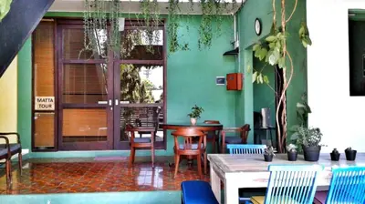 a room with a table and chairs and a window at Matta Lodge Bali in Jimbaran