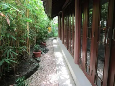a walkway next to a building with potted plants at Al-Isha Dharamshala in Kuta