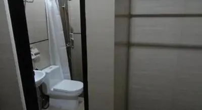 a bathroom with a toilet and a shower and a sink at Nakula Stay Kuta in Kuta