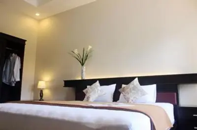 a bedroom with a large white bed in a room at Nakula Stay Kuta in Kuta