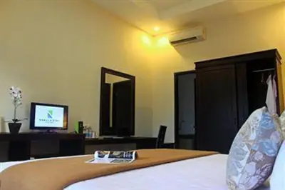 a bedroom with a bed with a tv in it at Nakula Stay Kuta in Kuta