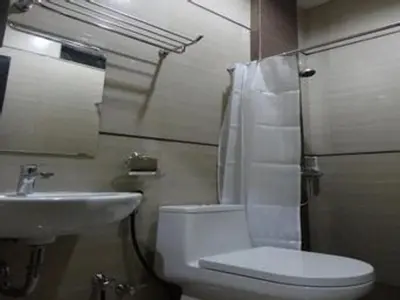 a bathroom with a white toilet and a sink at Nakula Stay Kuta in Kuta