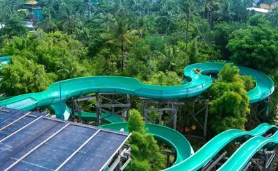 an amusement park with a water slide in the forest at Eazy Suite Legian in Legian