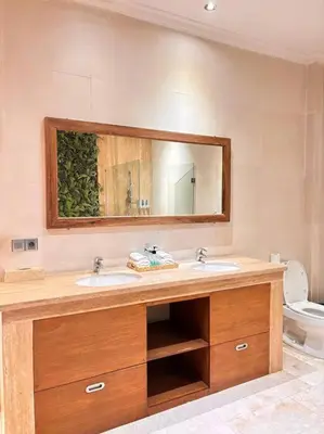 a bathroom with a sink and a mirror and a toilet at 4 Bedroom Tropical Luxury Villa in Seminyak