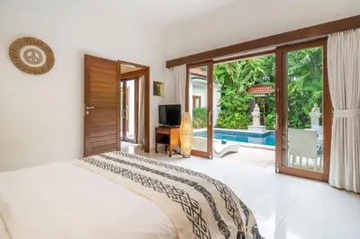 a bedroom with a bed and a sliding glass door at Villa Nemia Seminyak in Seminyak