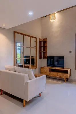 a living room with a couch and a tv at Green Loft Citarum in Sanur